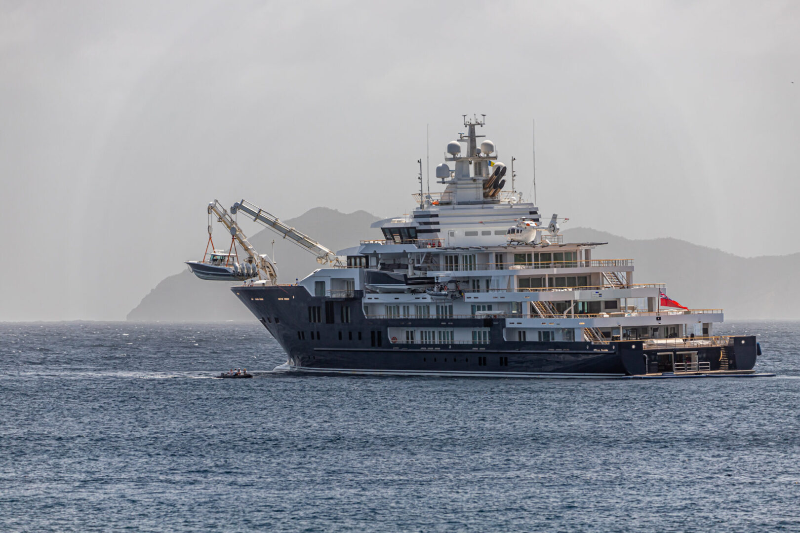 A large boat in the ocean with a crane on it.