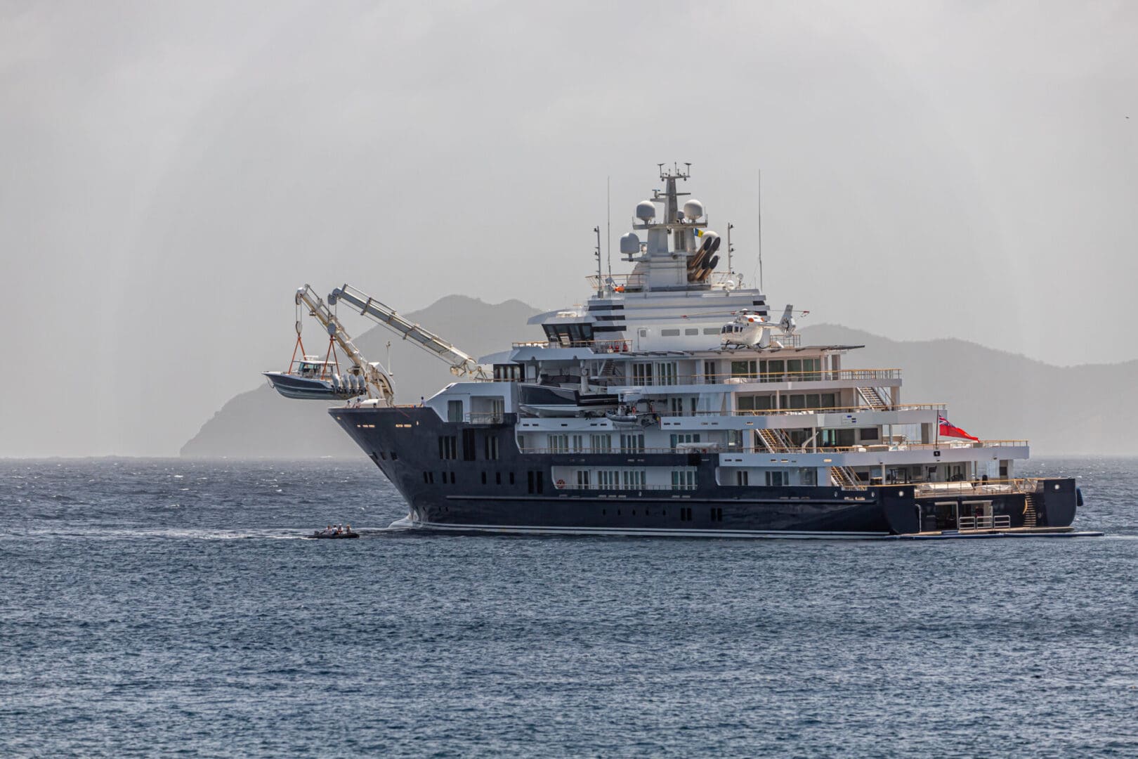 Superyacht launching a tender with crane systems, illustrating tender handling and towing operations relevant to TenderTow™ rigs.